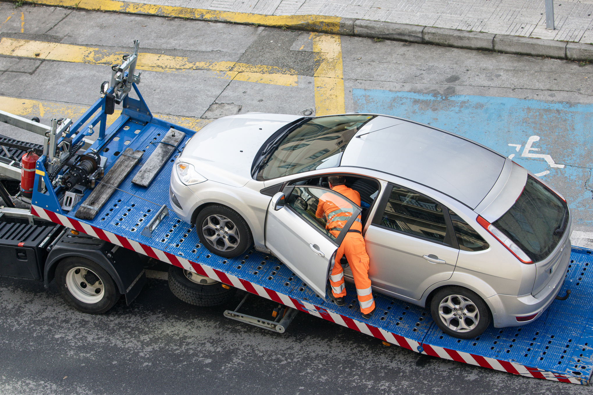 Damaged car being loaded onto tow truck. Roadside assistance concept